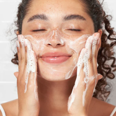 Woman applying a foaming face cleaner