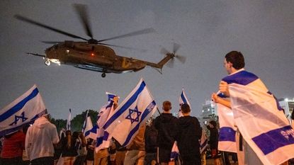 Israelis watch a helicopter with freed hostages land