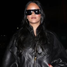 Rihanna and A$AP Rocky coordinated in black leather jackets, with RiRi in over-the-knee leather boots