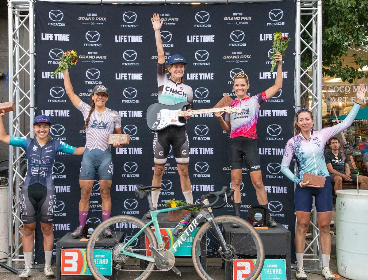 The 2023 women&#039;s Rad Dirt Fest podium, all finalists with award bricks and champion Lauren De Crescenzo with an electric guitar