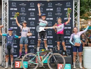 The 2023 women's Rad Dirt Fest podium, all finalists with award bricks and champion Lauren De Crescenzo with an electric guitar