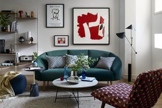 How to position a couch for a small living room, with a curved teal velvet sofa in a neutral scheme with gallery wall.