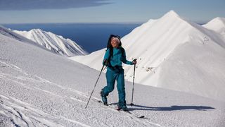 A woman on snowy ski slopes, wearing Patagonia Women’s Storm Shift Pants