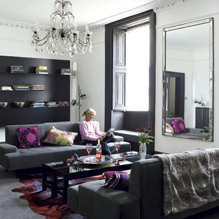 Living room with chandelier women and sofa set with cushion