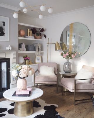 A grey living room with pink detailing and glam gold accessories