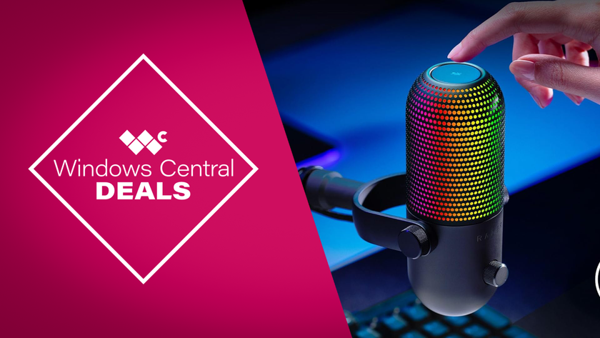 Razer Seiren V3 Chroma USB microphone with reactive RGB lighting, shown on a gaming desk setup alongside a keyboard and monitor.