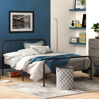 navy blue and grey bedroom with black metal bed and floating shelves