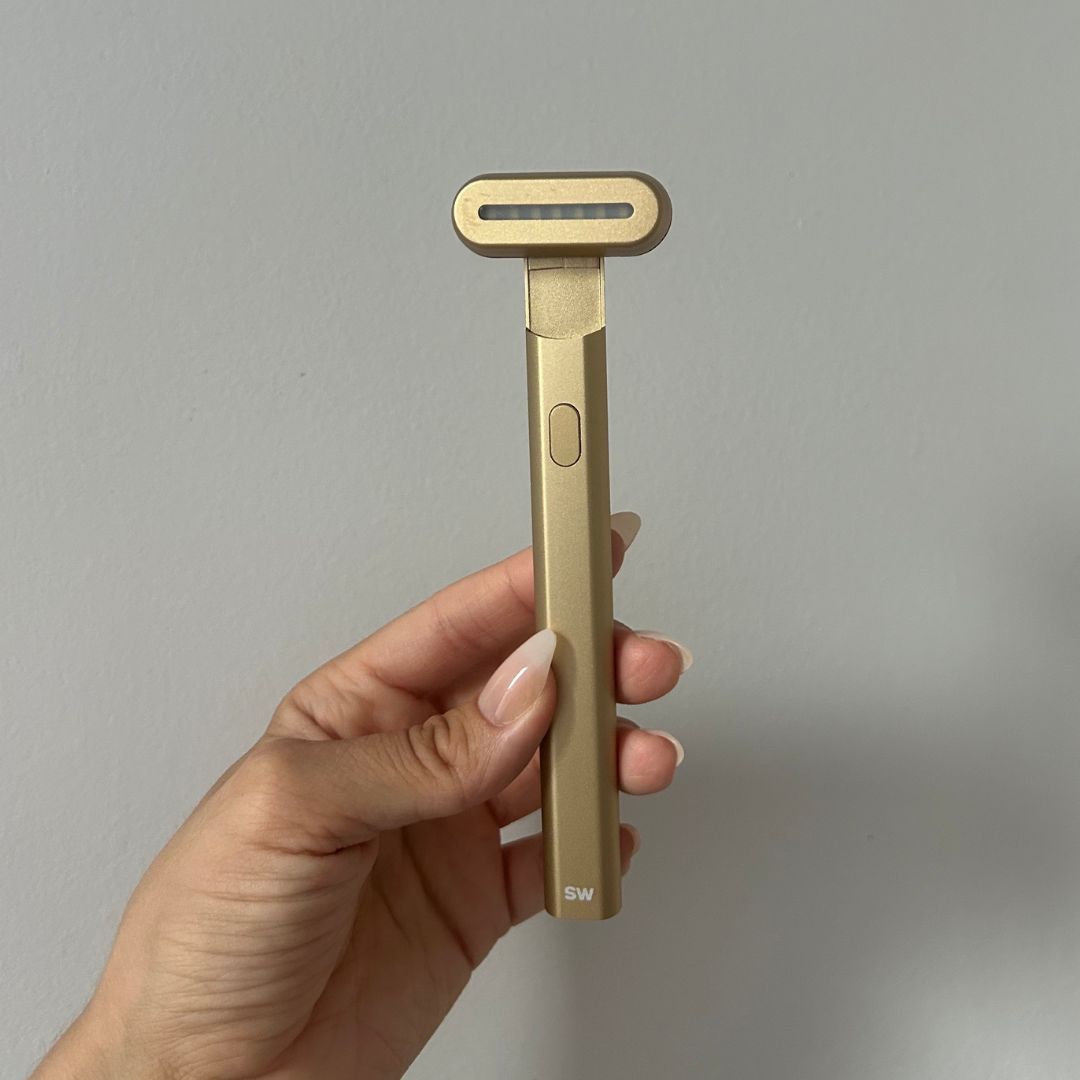 Alyssa Brascia holding the Solawave Skincare Wand in gold.