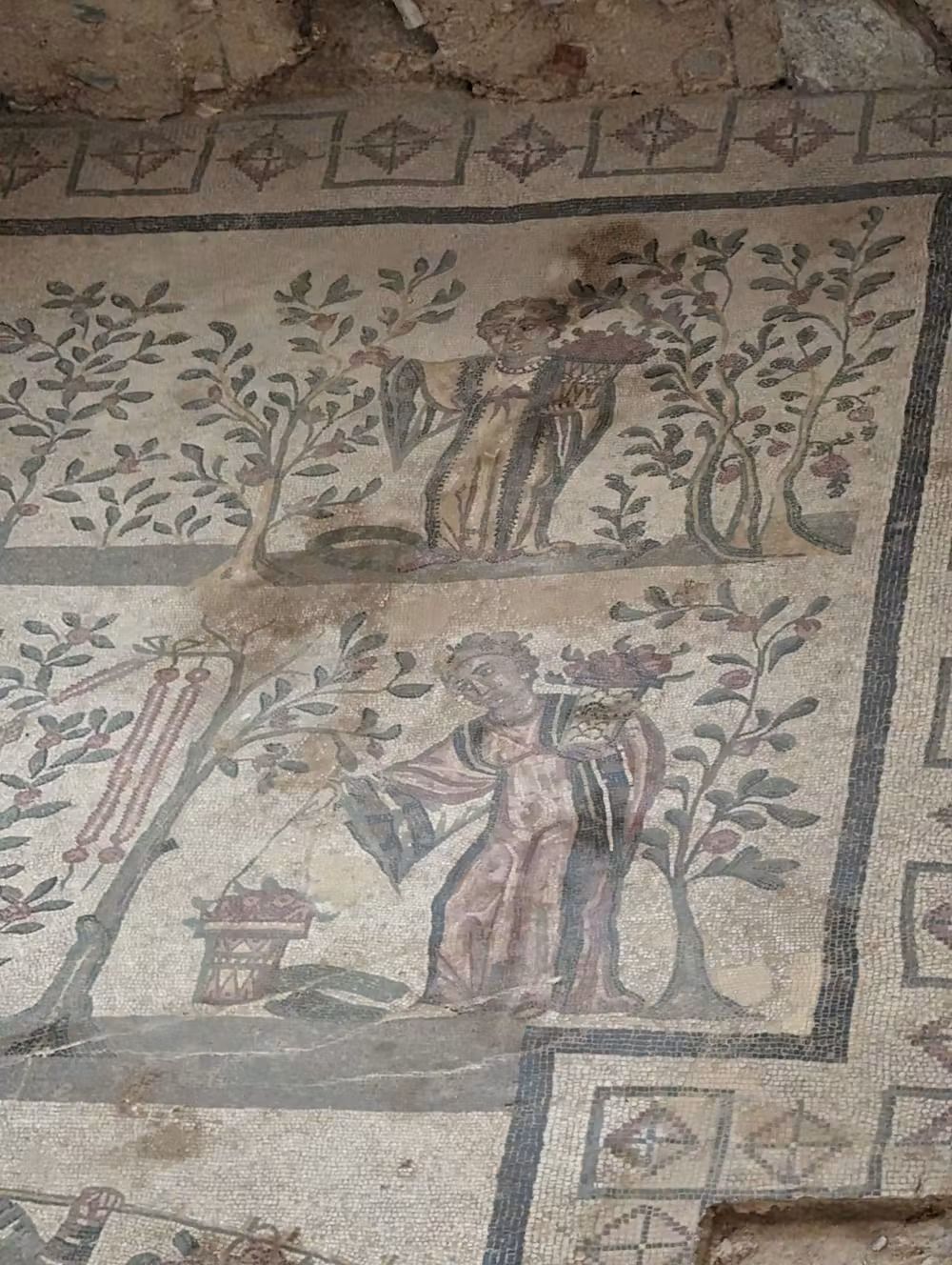 A close up of a mosaic of a woman in garden.