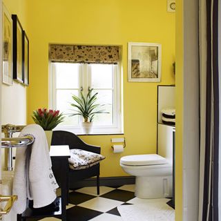 bathroom with yellow wall window and commode