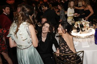 A photo of Kylie Jenner sitting with Chalamet in a lacy black long-sleeved gown at the 2024 Golden Globes.