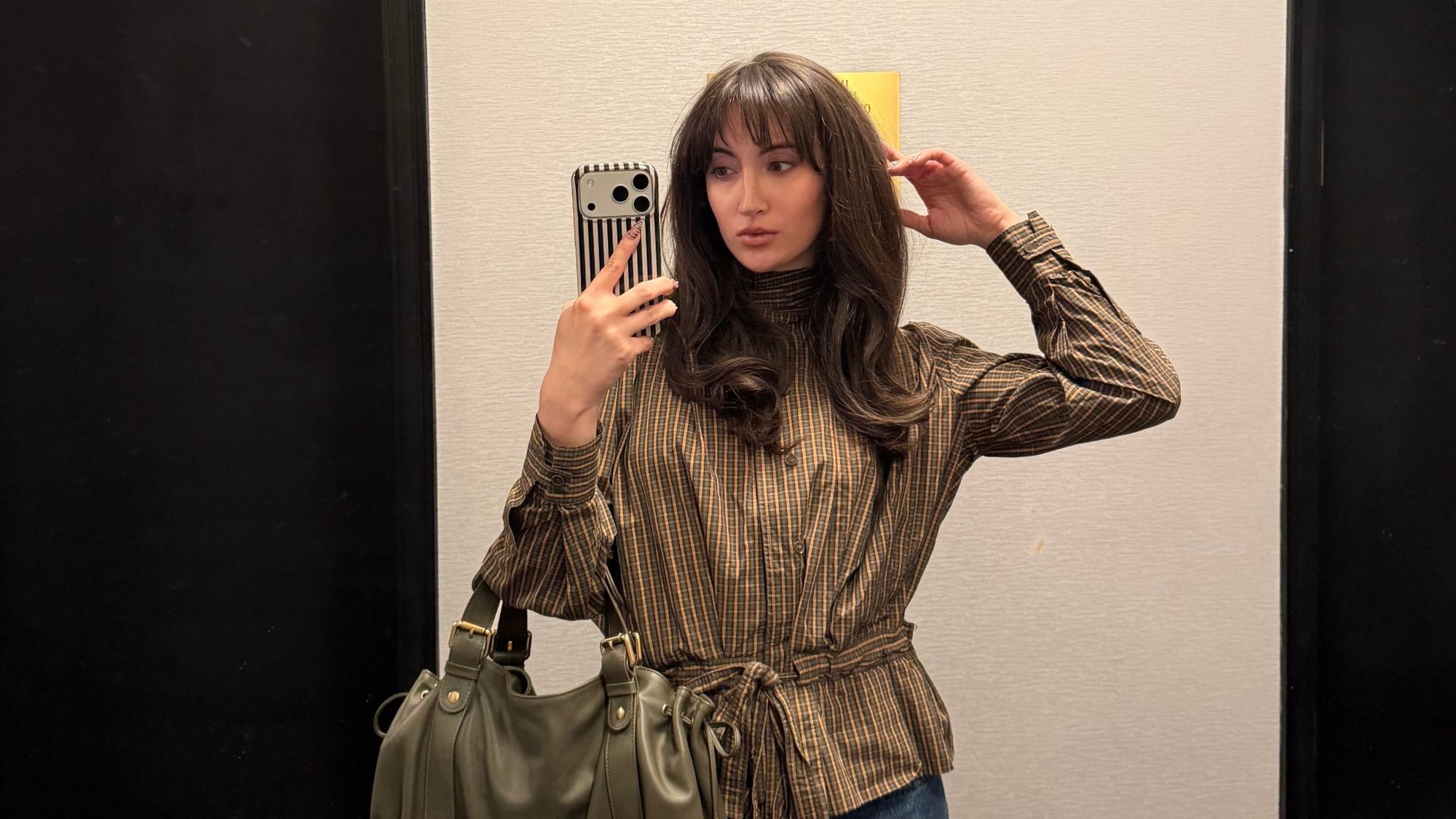 An image of Who What Wear associate beauty editor Alyssa Brascia taking a mirror selfie.