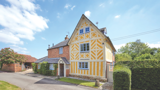 A striking yellow timber-framed and Hornton stone house