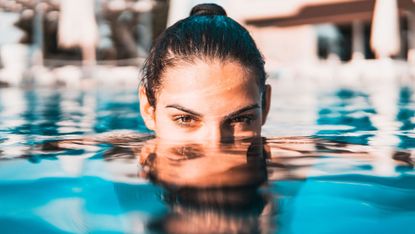 woman in a pool wearing sunscreen
