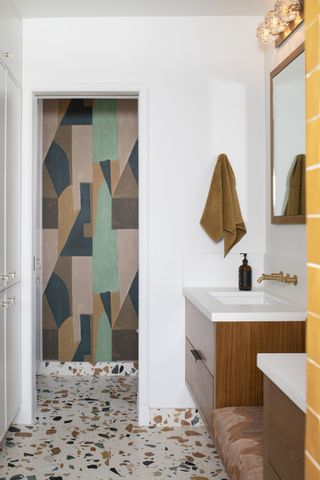 white bathroom with terrazzo floor tiles, wall mural, wall mounted vanities