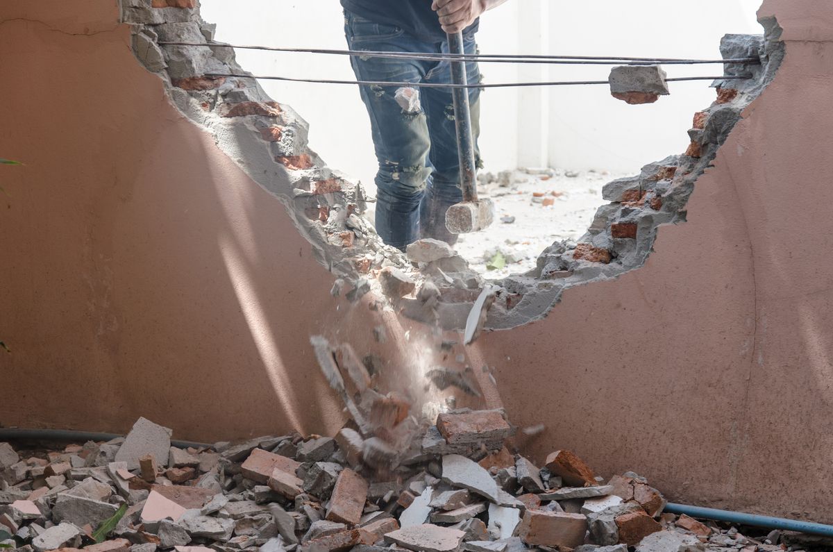 a person knocking down a wall in their home