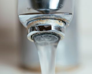 Soap scum and calcium buildup on a faucet caused by hard water