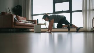 Woman performs mountain climber exercise at home