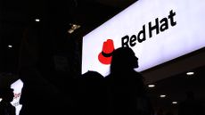 A visitor walks past US software company Red Hat logo at the Mobile World Congress (MWC), the telecom industry's biggest annual gathering, in Barcelona on February 27, 2023. 