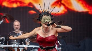 Sharon den Adel in an extravagant mask on stage