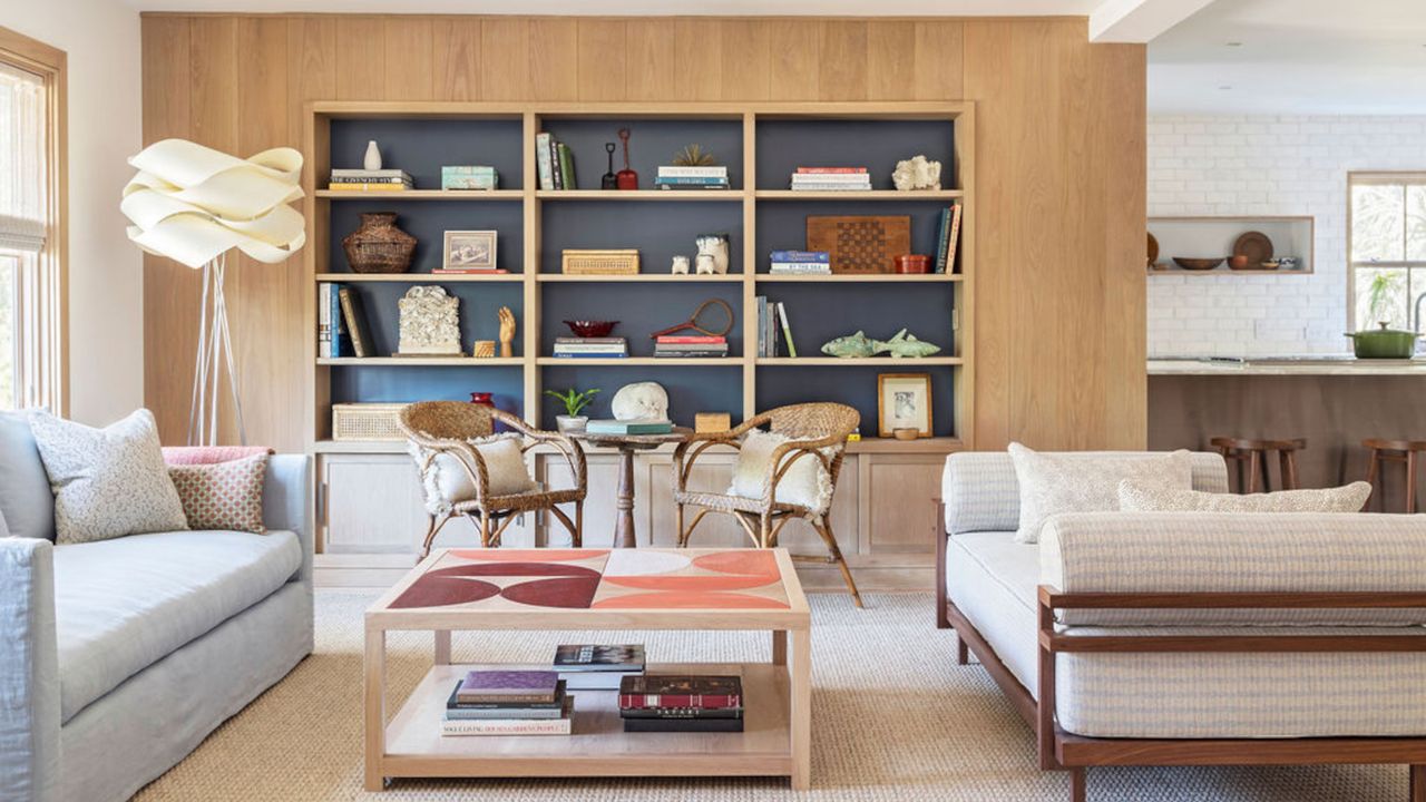 Living room with built-in oak cupboards with blue inset shelving, and a small dining set