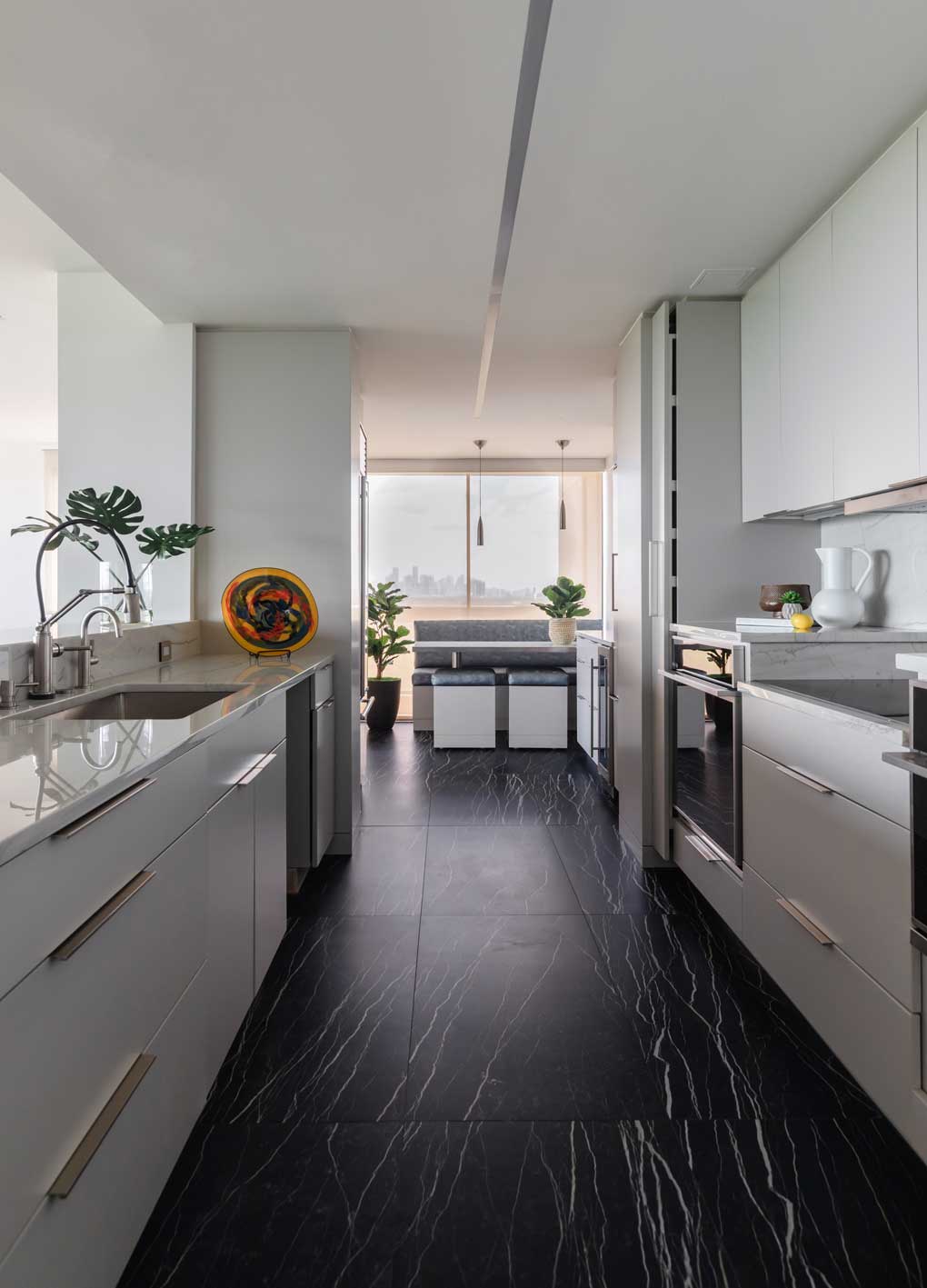 modern white galley kitchen with black marble flooring