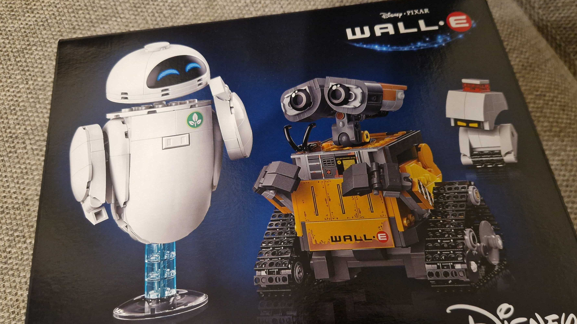 Lego WALL-E and EVE set box on a gray sofa