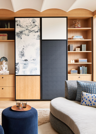 A modern living room with a cream barrel ceiling and wooden accent wall