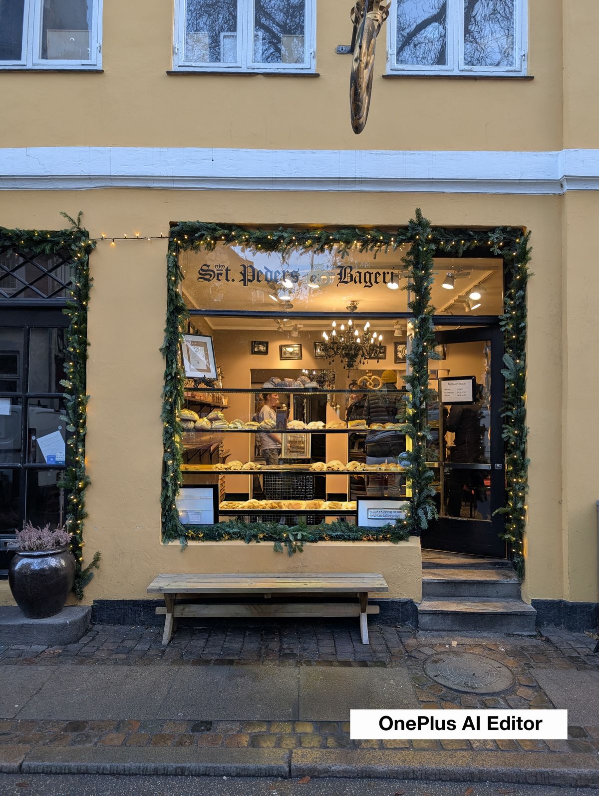 Two people outside a bakery window decorated for christmas