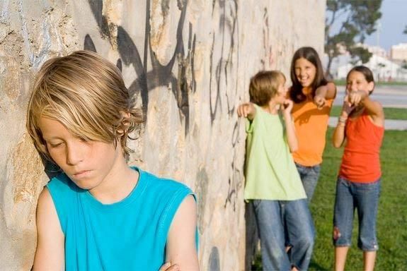 A group of girls bullying and laughing at another girl.