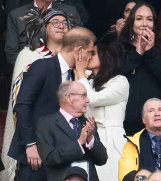 Meghan Markle kisses Prince Harry while wearing a cream alpaca coat, and meets a young girl at the Invictus Games 2025 in Canada