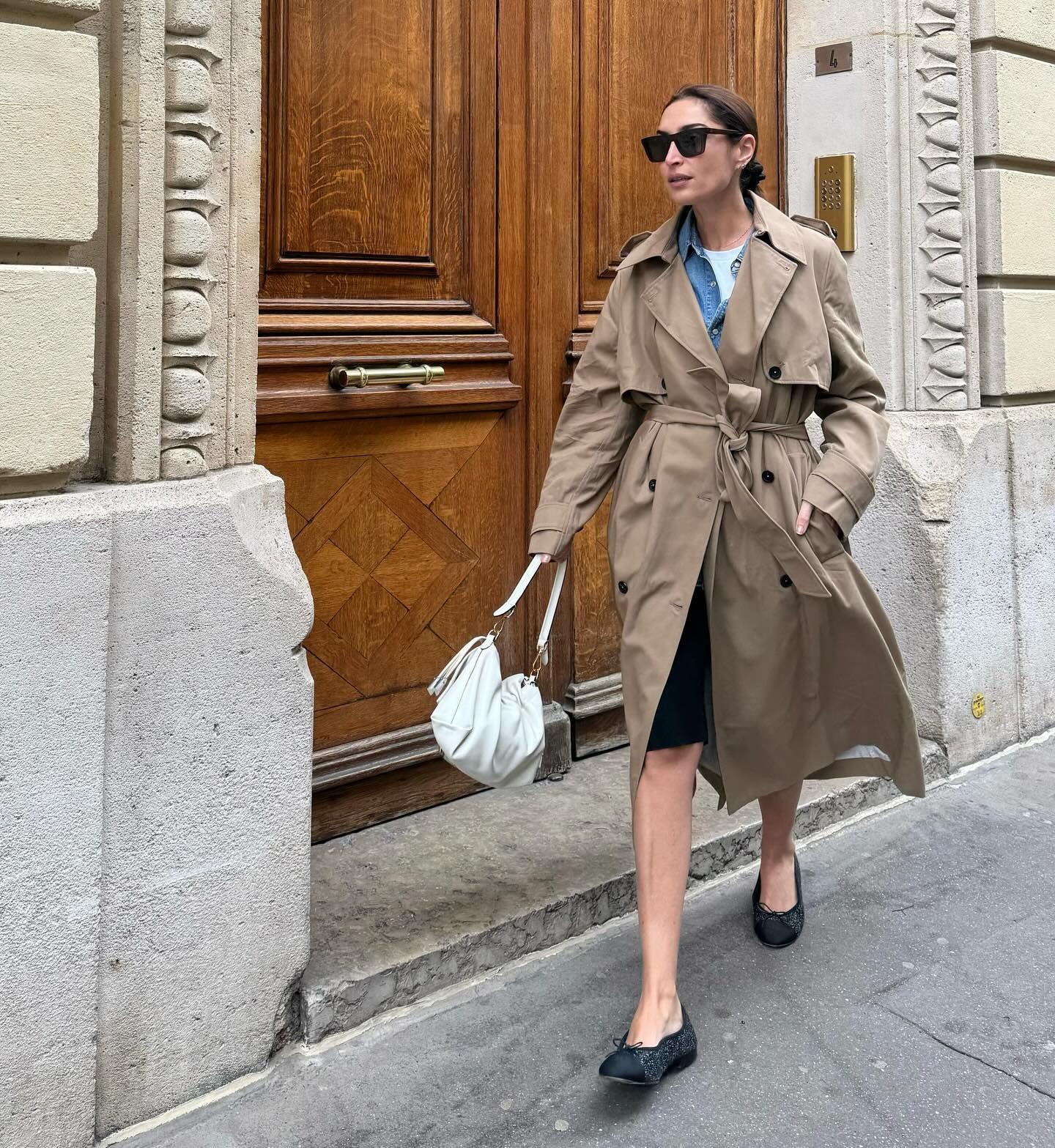 French woman wearing Bermuda shorts and black flats.