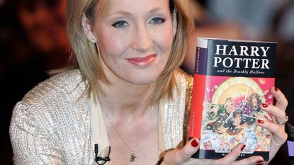 .K. Rowling holds a copy of "Harry Potter and the Deathly Hallows" SHAUN CURRY/AFP via Getty Images
