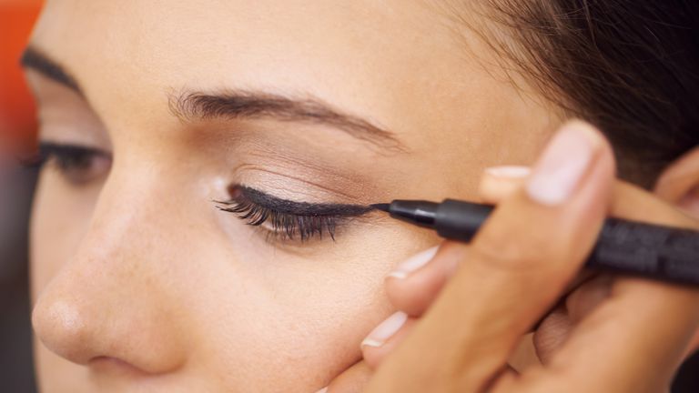 close up of woman applying liquid eyeliner