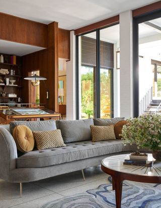 mid-century modern living room with curved sofa and wood paneling by Maestri Studios