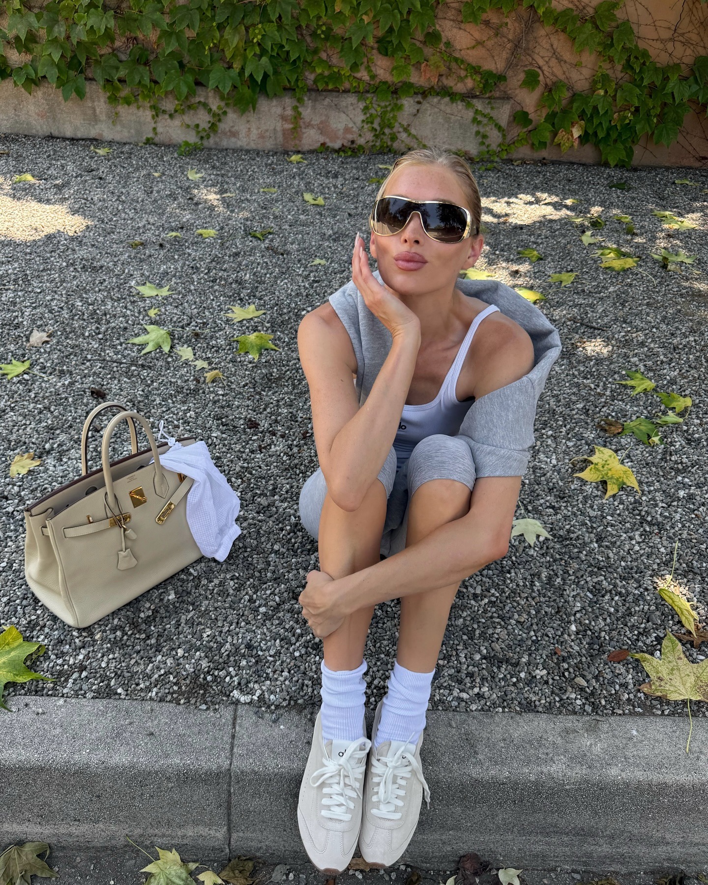 Elsa Hosk wearing gray Alo capri leggings and Alo suede sneakers