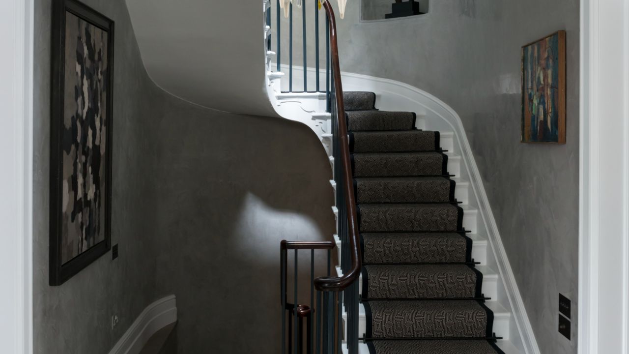 limewashed walls in landing with big light fixture