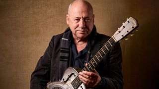 Mark Knopfler holds one of his prized resonator guitars