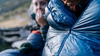 Two campers huddling in their sleeping bags