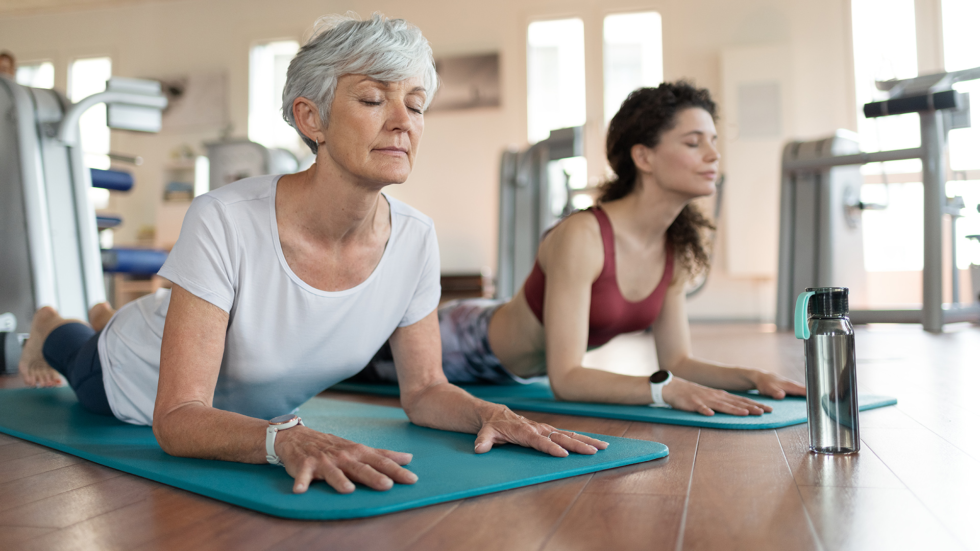 Two people doing yoga wearing Garmin watches