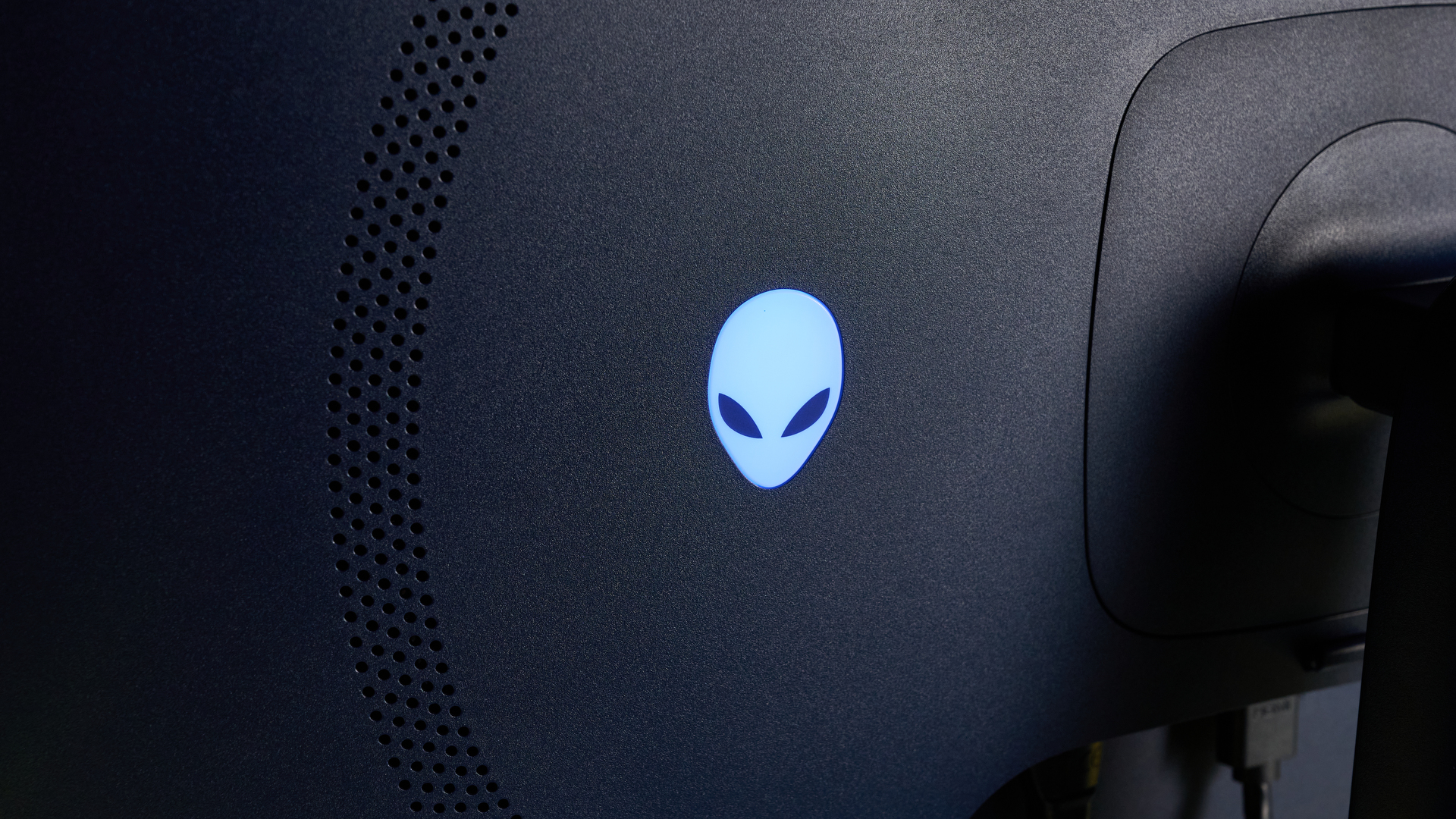 Alienware AW2725D on a desk against a blue background