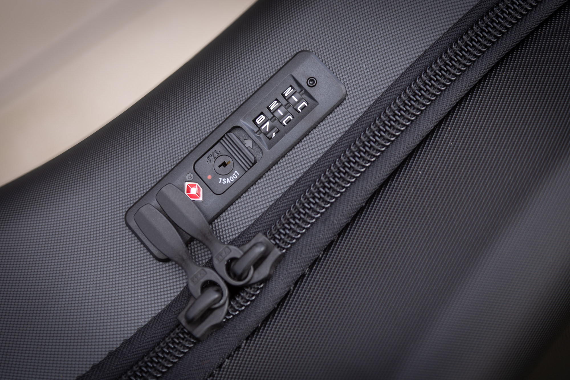 close up of a 3 digit combination lock on the zip of a bike bag