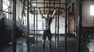 Man performing a pull-up in the gym 