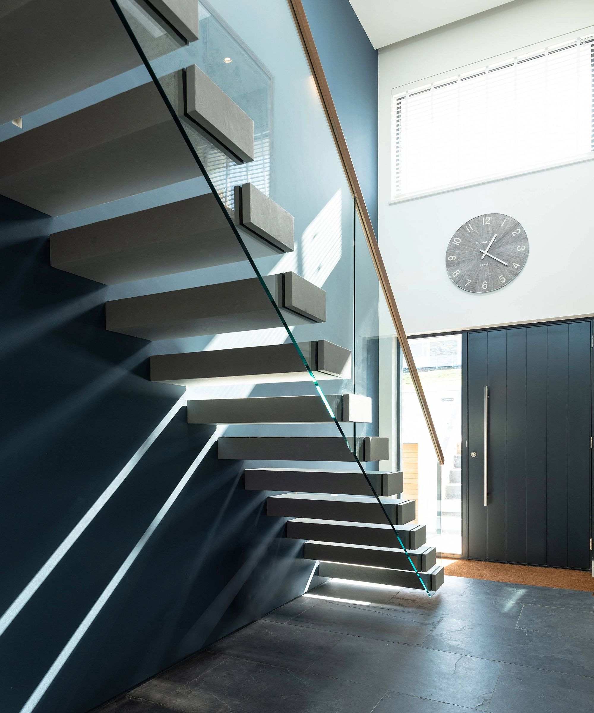 Staircase opposite the front door, with light coming through the window opposite