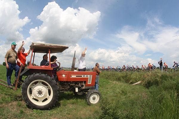 Farmers wave to the riders from the family auto.