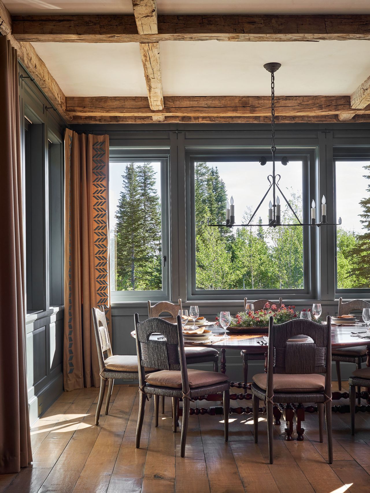 Dining room with wooden floor, dining table, chairs and exposed beams on ceiling