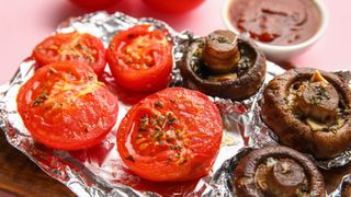 Cooked tomatoes and mushrooms on foil