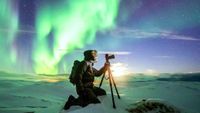 Photographer using one of the best cameras for low light photography to take images of the northern lights