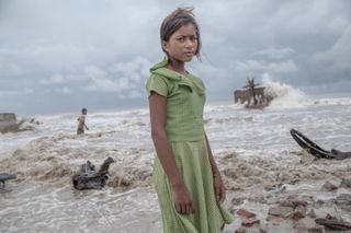 Girl standing in the ruins of her tea shop in the Sundarbans 