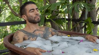 A man inside a tub with ice doing cryotherapy and meditating